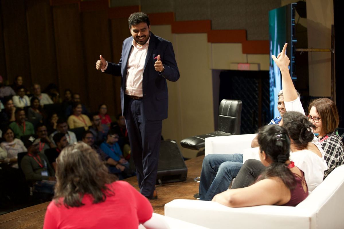 Antano speaking to the audience, a participant with her hand raised